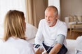 Health visitor and a senior man during home visit. Royalty Free Stock Photo