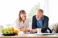 Health visitor and a senior man with tablet during home visit. Royalty Free Stock Photo