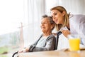 Health visitor and a senior woman during home visit.