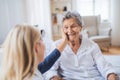 A health visitor talking to a sick senior woman sitting on bed at home. Royalty Free Stock Photo