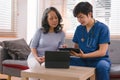 A health visitor is using a tablet to explain to a sick elderly woman how to take her pills.The visitor is taking Royalty Free Stock Photo