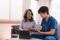 A health visitor is using a tablet to explain to a sick elderly woman how to take her pills.The visitor is taking Royalty Free Stock Photo