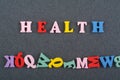 HEALTH word on black board background composed from colorful abc alphabet block wooden letters, copy space for ad text. Learning Royalty Free Stock Photo