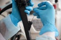 A health worker in blue gloves holds in hands a device for biopsy