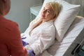 Health worker in orange uniform puts drip on beautiful woman Royalty Free Stock Photo