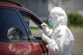 A health worker uses a CPR test mouth and nasal swab on a person inside a car to determine the presence or absence of the Covid-