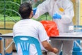 Health workers in a protective suit conduct a COVID-19 test for people at downtown