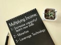 Business concept - text Multiplying Income with list of advice on notepad background. Stock photo. Royalty Free Stock Photo