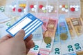 healthcare cardholder holds European health insurance card, euros money, medicines, blue EU document healthcare support, medicines