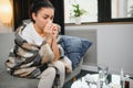 healthcare, cold, allergy and people concept - sick woman blowing her runny nose in paper tissue at home. Royalty Free Stock Photo