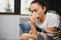 healthcare, cold, allergy and people concept - sick woman blowing her runny nose in paper tissue at home. Royalty Free Stock Photo