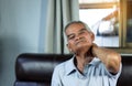 Healthcare concept. Asian Older man suffering from shoulder pain sitting on sofa. Health problem retired asian old man hands Royalty Free Stock Photo