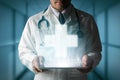 Doctor displays medical cross symbol from tablet. Royalty Free Stock Photo