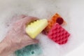 Healthcare concept. Hygiene during the spread of coronavirus COVID-19. View of a soapy sponge, foam soap bubbles & male hand. Royalty Free Stock Photo