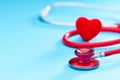 Red heart and stethoscope on on blue background.Selective focus.