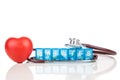 Healthcare concept with pill organizer box for storing doses of daily medicine, with red heart and stethoscope as prop Royalty Free Stock Photo