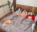 Sick family in protective masks lying in bed