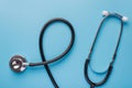 Healthcare concept. Top above overhead flatlay close up photo of black stethoscope phonendoscope isolated on pastel blue Royalty Free Stock Photo