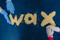 Healthcare Concepts. Hands of Depilation Professonals In Front of Granules of Wax for Depilation On Blue Textile Background Royalty Free Stock Photo