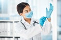 Healthcare, covid and a doctor putting gloves on hands, woman ready for check up examination or surgery in hospital or Royalty Free Stock Photo