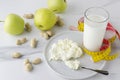 Concept of delicious meal for milk diet and loss weight.Glass of milk,plate with cottage cheese,green apples,peanuts on white tabl Royalty Free Stock Photo