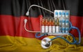 Healthcare, insurance and pharmacy in Germany concept. Pills, vaccine, syrringe and stethoscope in German flag