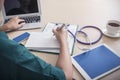 Healthcare and medical concept. Doctor working with laptop, mobile, tablet, stethoscope, calendar and coffee cup on table in