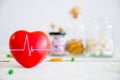 Healthcare and medical concept. Red heart on wooden table with set of medicine bottles and medicine pills background.