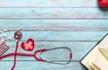 Healthcare and medical concept red stethoscope and medicine on the blue wooden background Royalty Free Stock Photo