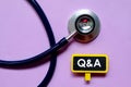 Healthcare and medical concept. Stethoscope and blackboard written with Q&A on purple background Royalty Free Stock Photo