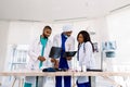 Healthcare, medical: Group of three young African doctors, two men and woman, discuss and looking x-ray in a clinic or Royalty Free Stock Photo