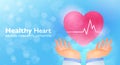 Healthcare and medical insurance banner. Doctor hands rising the heart with pulse graph on light blue bokeh background. Royalty Free Stock Photo