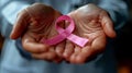 Healthcare, medicine and breast cancer awareness concept - close up of doctor hands holding pink ribbon Royalty Free Stock Photo