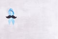 Healthcare and medicine concept - blue prostate cancer awareness ribbon and paper black mustache, achalasia and adrenocortical