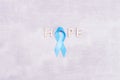 Healthcare and medicine concept - blue prostate cancer awareness ribbon and word hope made of wooden letters, achalasia and