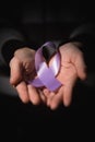 healthcare concept - child hands holding cancer awareness ribbon Royalty Free Stock Photo
