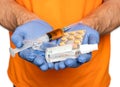 Close up of male hands in protective gloves holding pills, ampule, syringe and antiseptic over white background