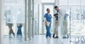 Healthcare, nurse and doctor talking, walking in lobby and consultation for advice, diagnosis and tablet. Medical Royalty Free Stock Photo