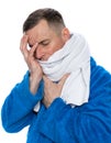 Sick man in a bathrobe wrapped in a towel over white background