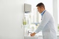 Doctor washing hands at medical clinic sink