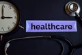 Healthcare on the print paper with Healthcare Concept Inspiration. alarm clock, Black stethoscope. Royalty Free Stock Photo