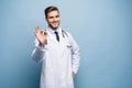 Healthcare, profession, gesture, people and medicine concept - smiling male doctor in white coat showing ok hand sign.