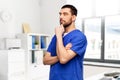 thinking doctor or male nurse in blue uniform Royalty Free Stock Photo
