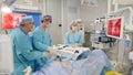 Healthcare. Reveal surgical hospital specialist team in scrubs in operating theatre performing laparoscopic surgery