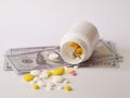 Healthcare savings and expencive medicine concept. Pills scattered over dollar banknotes. Bottle of pills and money Royalty Free Stock Photo