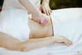 Massage therapist in spa salon massaging clients stomach