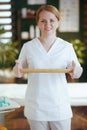 happy massage therapist woman in massage cabinet