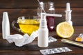 healthcare, traditional medicine and flu concept - cup of tea with lemon, thermometer and drugs on wooden table. Royalty Free Stock Photo