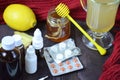 Healthcare, traditional medicine and flu concept - tea cup with lemon, ginger, honey and pills on wooden table. tablets Royalty Free Stock Photo