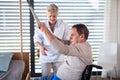 A healthcare worker helping paralysed senior patient in hospital. Royalty Free Stock Photo